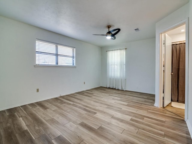 unfurnished bedroom featuring light wood-style floors, visible vents, baseboards, and ceiling fan