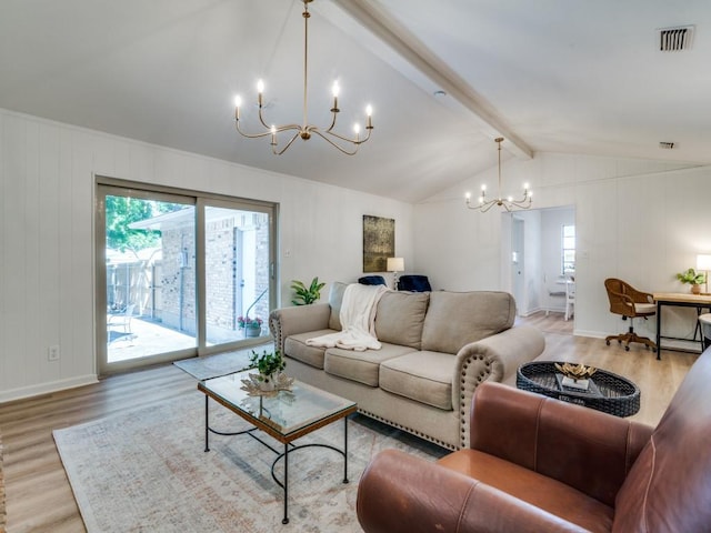 living area with plenty of natural light, wood finished floors, and a chandelier