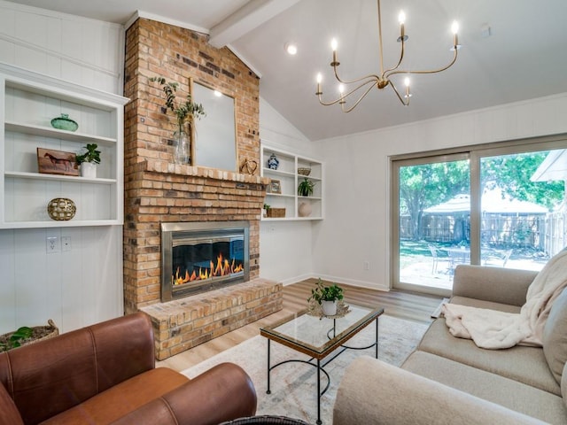 living area featuring lofted ceiling with beams, baseboards, a notable chandelier, wood finished floors, and a fireplace