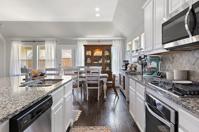 2452 Open Range Dr, Fort Worth, TX 76177 - kitchen featuring stainless steel appliances, a sink, white cabinets, dark wood-style floors, and decorative backsplash