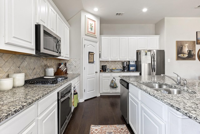 2452 Open Range Dr, Fort Worth, TX 76177 - kitchen featuring appliances with stainless steel finishes, a sink, dark wood-type flooring, white cabinetry, and light stone countertops