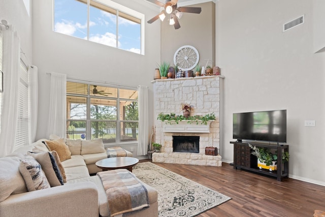 3001 Shoreline Dr, Burleson, TX 76028 - living area with a towering ceiling, a ceiling fan, dark wood-style flooring, a stone fireplace, and baseboards