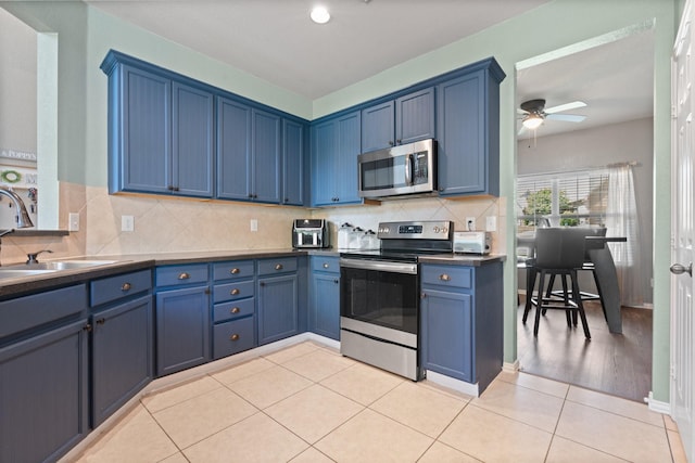 3001 Shoreline Dr, Burleson, TX 76028 - kitchen with appliances with stainless steel finishes, a sink, blue cabinets, a ceiling fan, and dark countertops