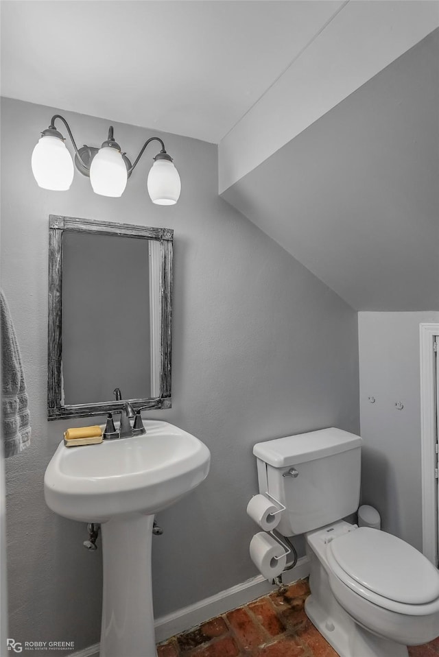 half bathroom featuring baseboards and toilet