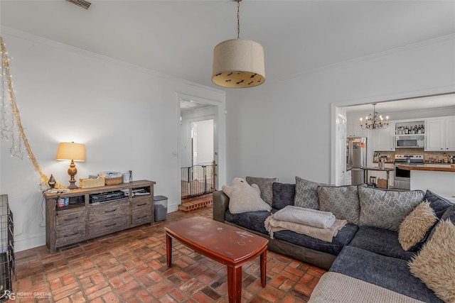 living room with brick flooring, a chandelier, baseboards, and ornamental molding