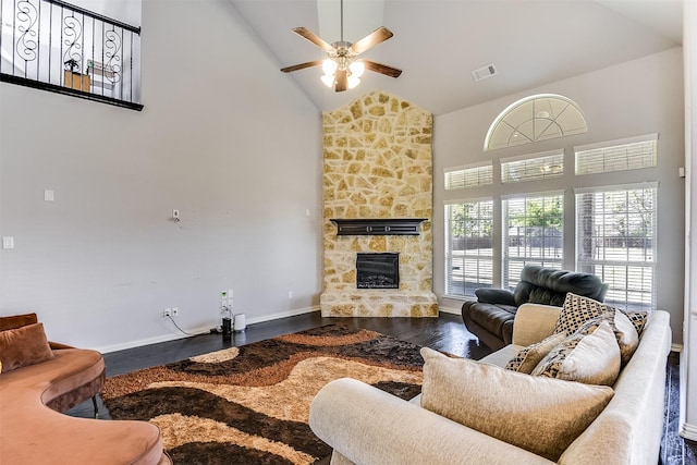 living room featuring wood finished floors, visible vents, a fireplace, high vaulted ceiling, and ceiling fan