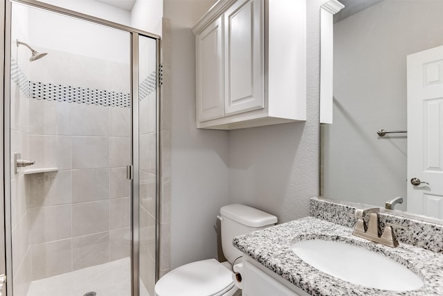 full bathroom featuring toilet, vanity, and a stall shower