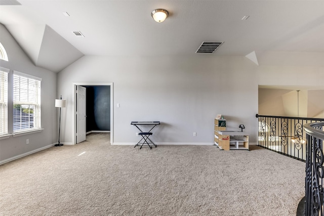 interior space with carpet floors, visible vents, lofted ceiling, and baseboards