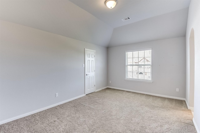 spare room with baseboards, vaulted ceiling, visible vents, and carpet