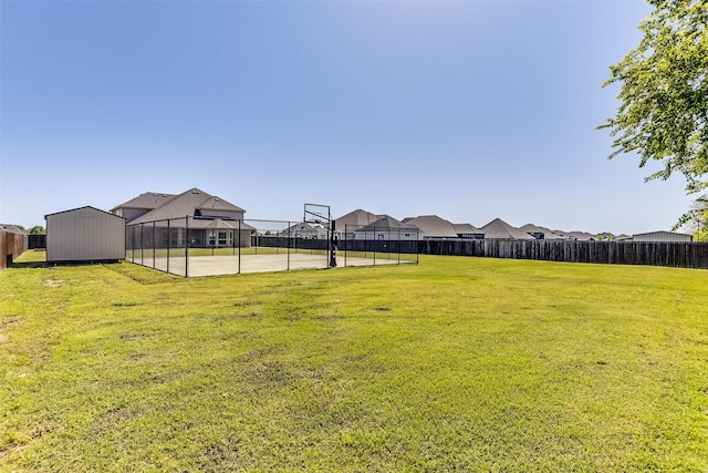 view of yard featuring community basketball court and fence