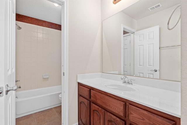 bathroom featuring toilet, bathtub / shower combination, visible vents, tile patterned flooring, and vanity