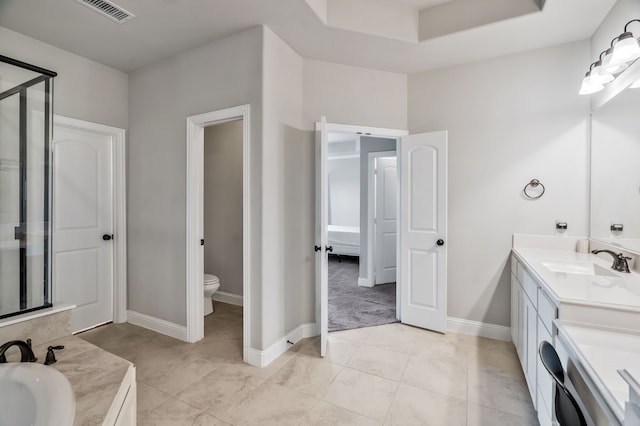 bathroom with toilet, a stall shower, baseboards, visible vents, and vanity