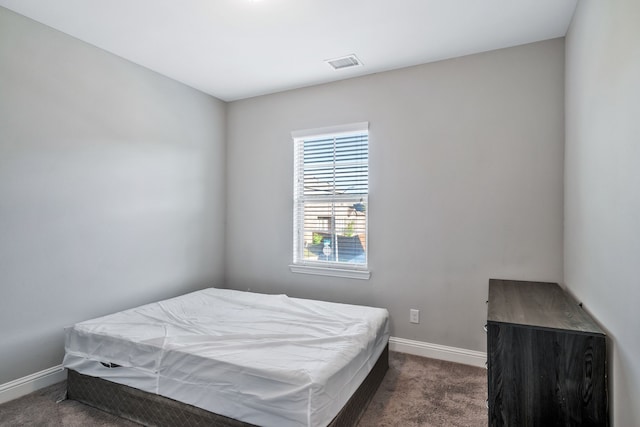 bedroom featuring dark carpet, visible vents, and baseboards