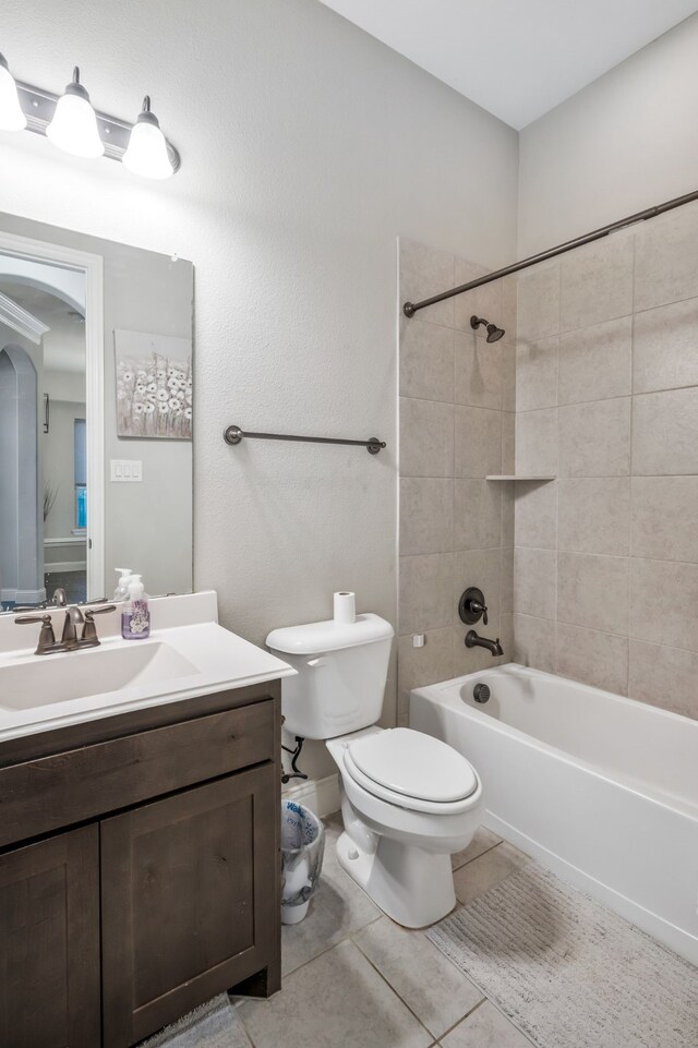 bathroom featuring tile patterned flooring, washtub / shower combination, toilet, and vanity