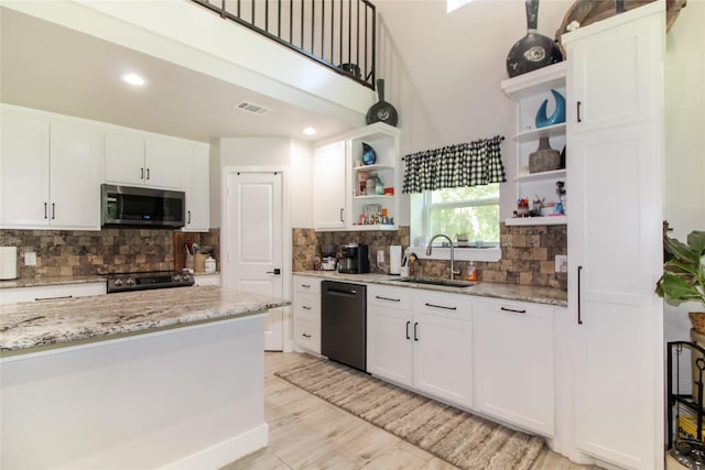 kitchen with open shelves, a sink, stainless steel microwave, black dishwasher, and visible vents