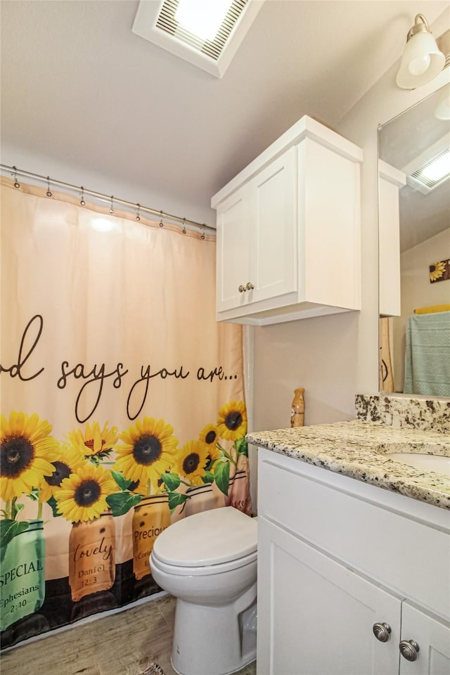 full bathroom with wood finished floors, vanity, toilet, a shower with shower curtain, and visible vents