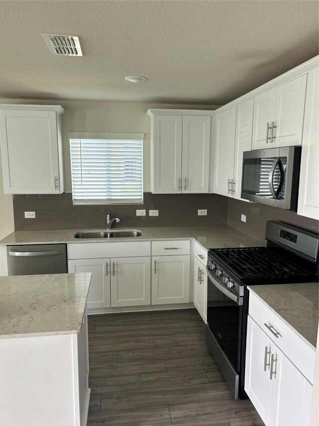 16033 Rein Ave, Haslet, TX 76052 - kitchen featuring white cabinets, stainless steel appliances, visible vents, a sink, and a textured ceiling