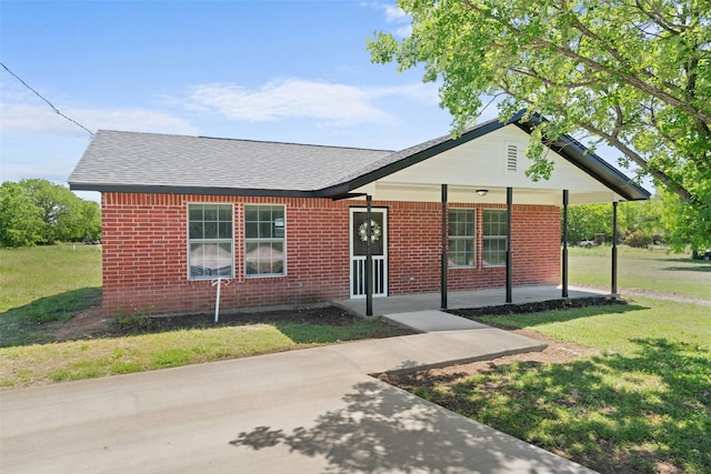 ranch-style home featuring a front lawn, brick siding, and a shingled roof