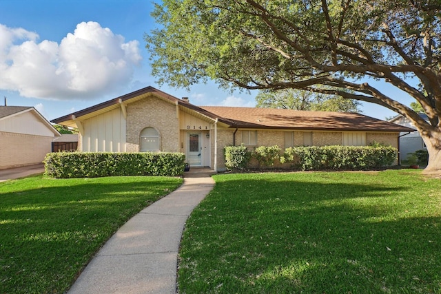 3141 La Kenta Cir, Farmers Branch, TX 75234 - view of front of home with a front yard, brick siding, and board and batten siding