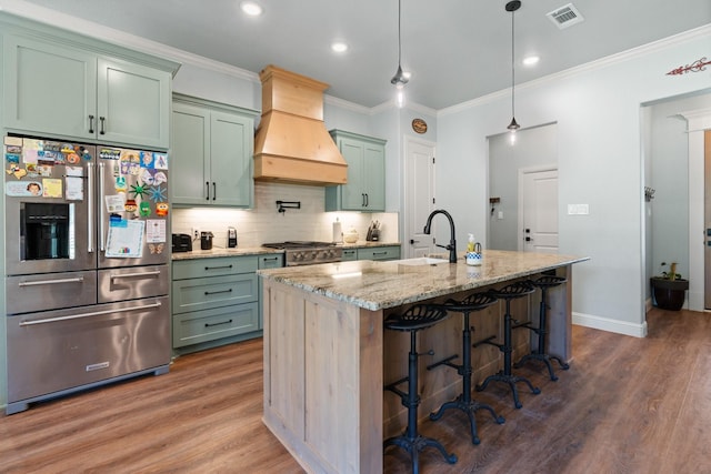 1295 County Road 2030, Glen Rose, TX 76043 - kitchen with high quality fridge, green cabinets, custom range hood, dark wood finished floors, and crown molding