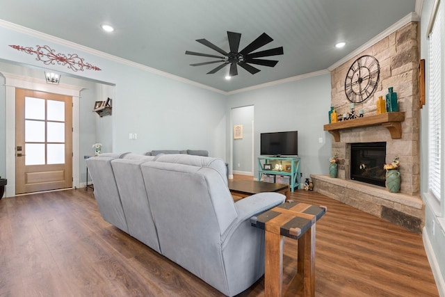 1295 County Road 2030, Glen Rose, TX 76043 - living room featuring crown molding, dark wood-type flooring, ceiling fan, a stone fireplace, and plenty of natural light