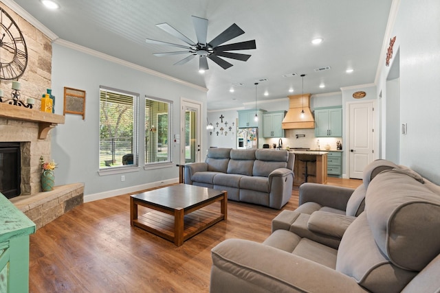 1295 County Road 2030, Glen Rose, TX 76043 - living room with ornamental molding, a ceiling fan, wood finished floors, a fireplace, and recessed lighting