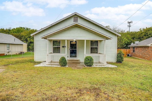 bungalow featuring central AC unit, a porch, a front yard, and fence