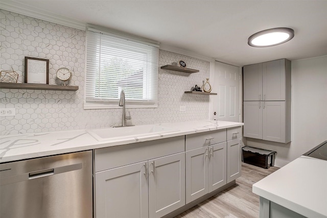 kitchen featuring open shelves, stainless steel dishwasher, a sink, and light wood-style floors