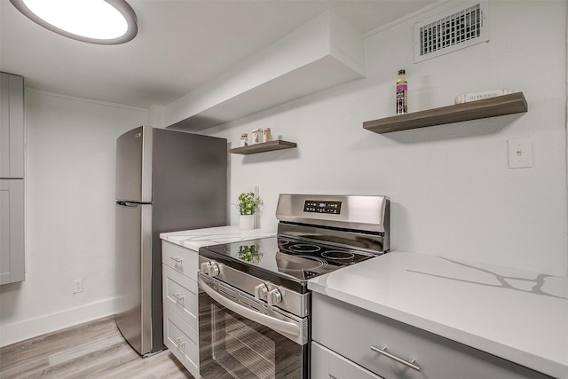 kitchen featuring stainless steel appliances, visible vents, light wood-style floors, open shelves, and light countertops