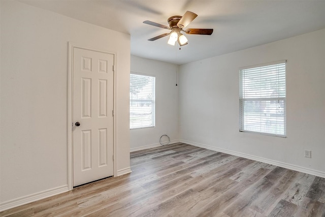 unfurnished room with light wood finished floors, baseboards, and ceiling fan