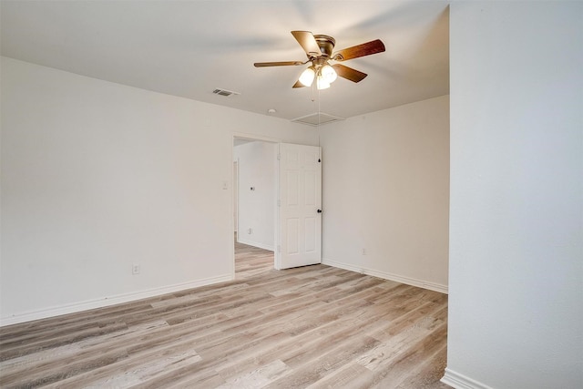 spare room featuring baseboards, a ceiling fan, visible vents, and light wood-type flooring