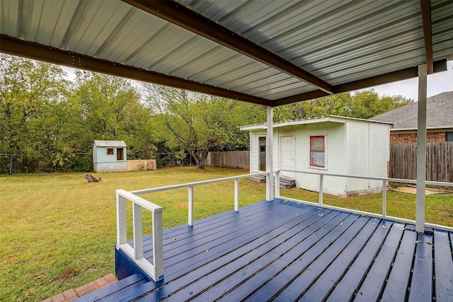 deck featuring a yard, a storage unit, an outbuilding, and a fenced backyard