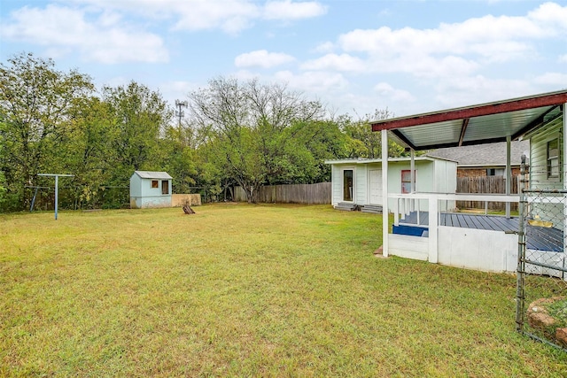 view of yard featuring a storage shed, fence, an outbuilding, entry steps, and a wooden deck
