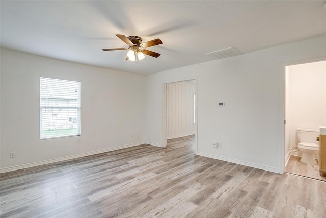 unfurnished room featuring light wood finished floors, baseboards, visible vents, and ceiling fan