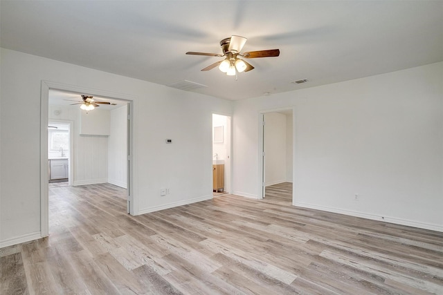empty room with ceiling fan, baseboards, light wood finished floors, and visible vents