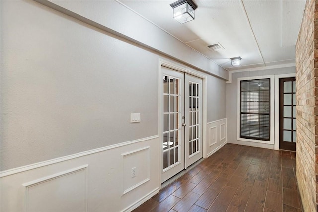 102 Park Cir, Mckinney, TX 75069 - doorway featuring french doors, dark wood finished floors, a decorative wall, and a wainscoted wall