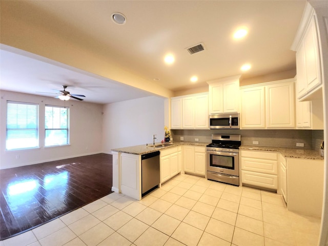 4223 Cascade Sky Dr, Arlington, TX 76005 - kitchen featuring light stone countertops, stainless steel appliances, a sink, visible vents, and a peninsula