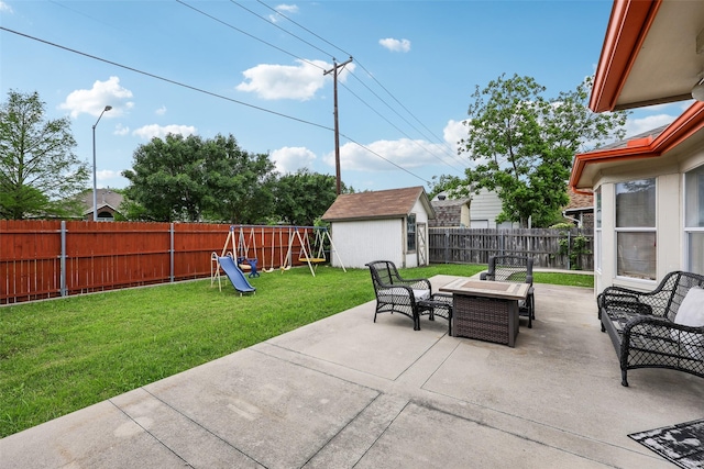 view of patio / terrace featuring an outdoor structure, a fenced backyard, a playground, and a storage shed