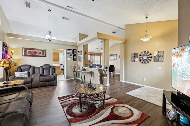 living area featuring visible vents, a textured ceiling, and lofted ceiling