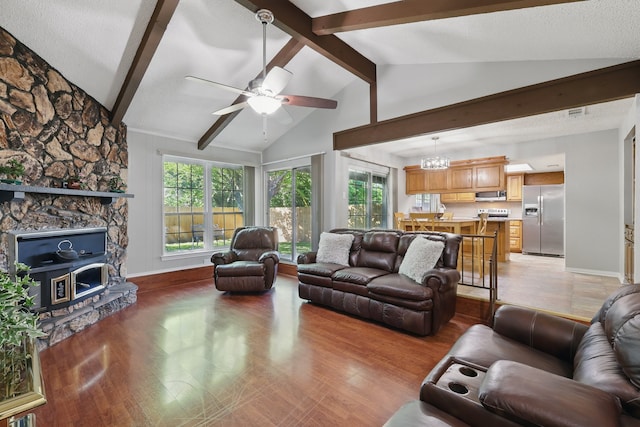 living room featuring a healthy amount of sunlight, vaulted ceiling with beams, and light wood-type flooring