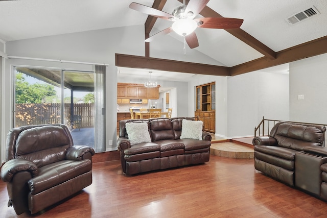 living area with wood finished floors, visible vents, beam ceiling, high vaulted ceiling, and ceiling fan