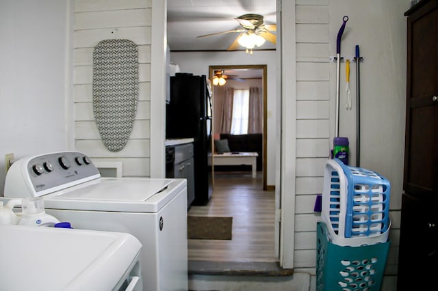 laundry room with washing machine and dryer, a ceiling fan, wood finished floors, and laundry area