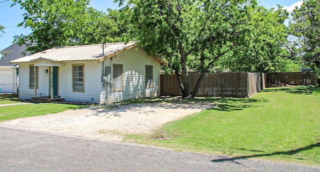 ranch-style house with fence, metal roof, and a front yard