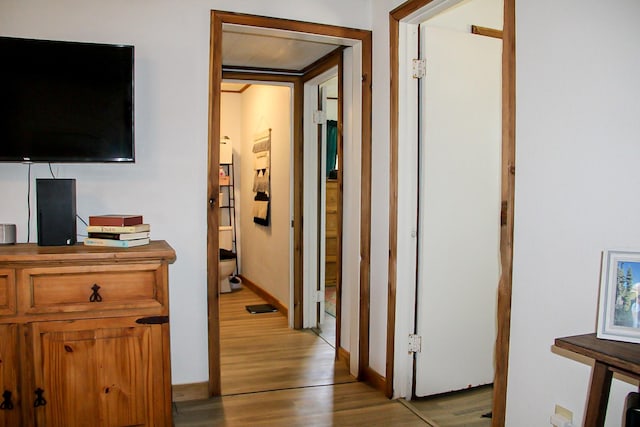 hall featuring light wood finished floors and baseboards