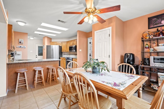 dining space featuring a ceiling fan, light tile patterned flooring, and visible vents