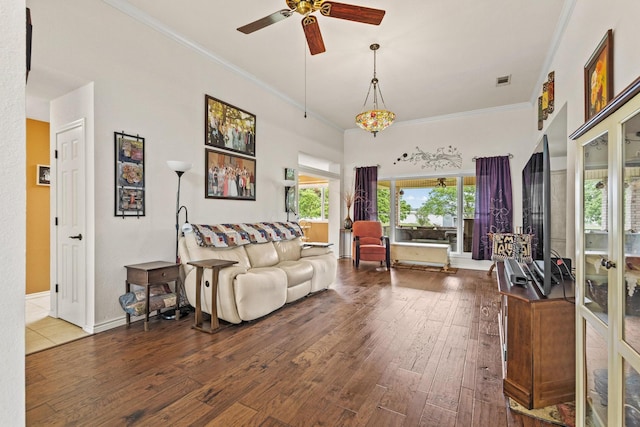 living room featuring hardwood / wood-style floors, visible vents, a ceiling fan, crown molding, and baseboards