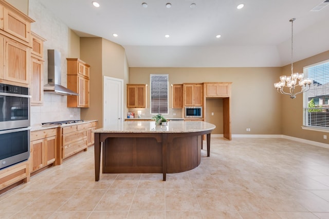 kitchen featuring stainless steel appliances, vaulted ceiling, wall chimney range hood, visible vents, and a chandelier