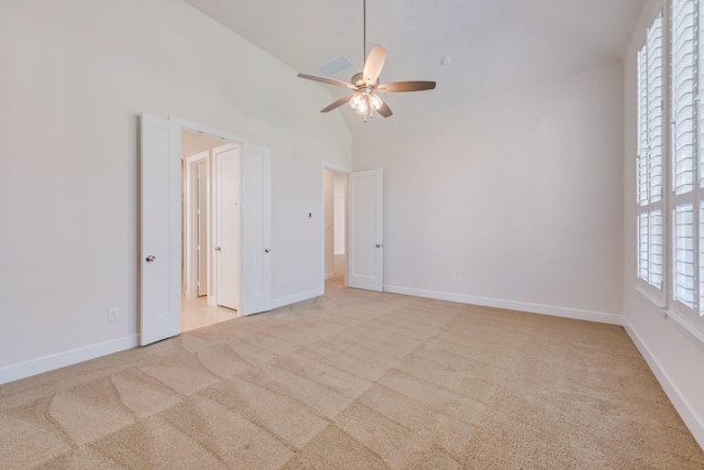 unfurnished bedroom with high vaulted ceiling, ceiling fan, baseboards, and carpet