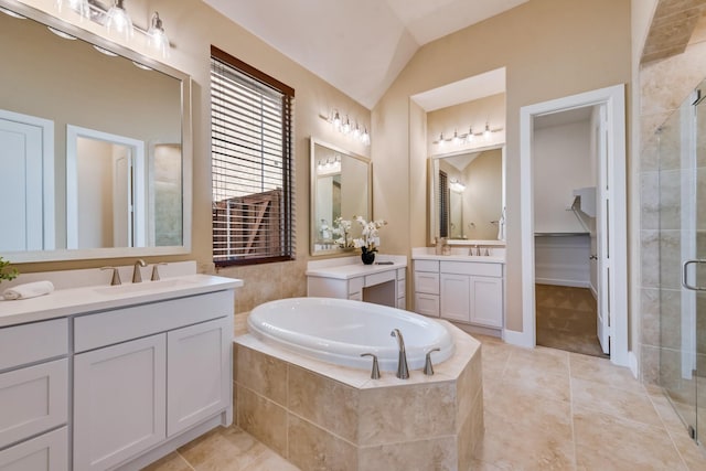 bathroom with a shower stall, vaulted ceiling, a garden tub, and a sink