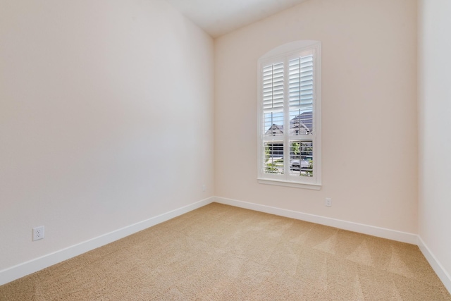 spare room with baseboards and carpet